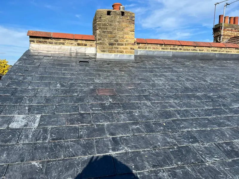 Chimney stack with new lead flashing above a slate roof