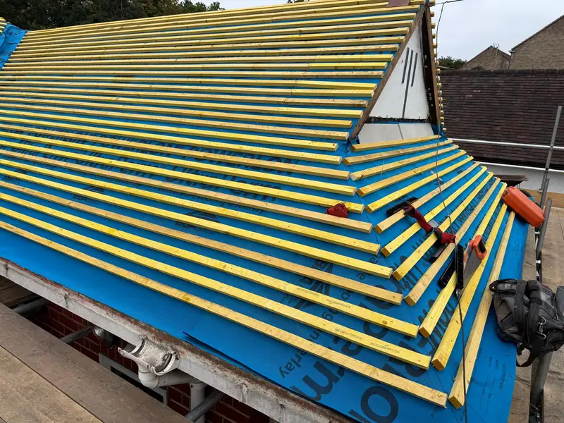 The same bungalow roof stripped, with blue membrane and new battens