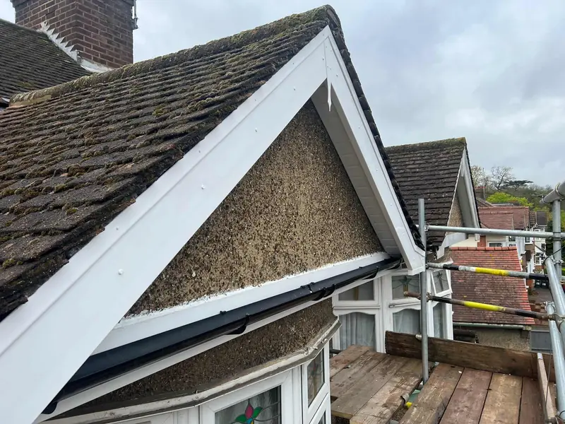 New white bargeboards on a pebble-dashed gable, fitted from the scaffold